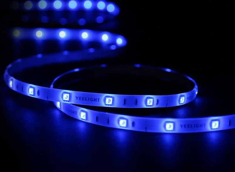 Iluminación de tira LED azul, curvándose sobre una superficie negra. Luces espaciadas uniformemente.