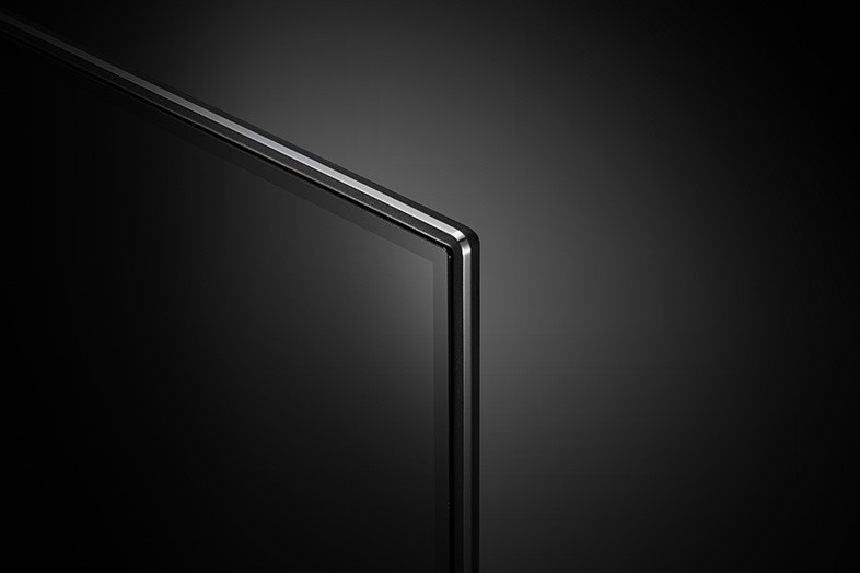 Una vista de cerca de una esquina de una pantalla de TV negra, diseño elegante y minimalista, fondo oscuro.