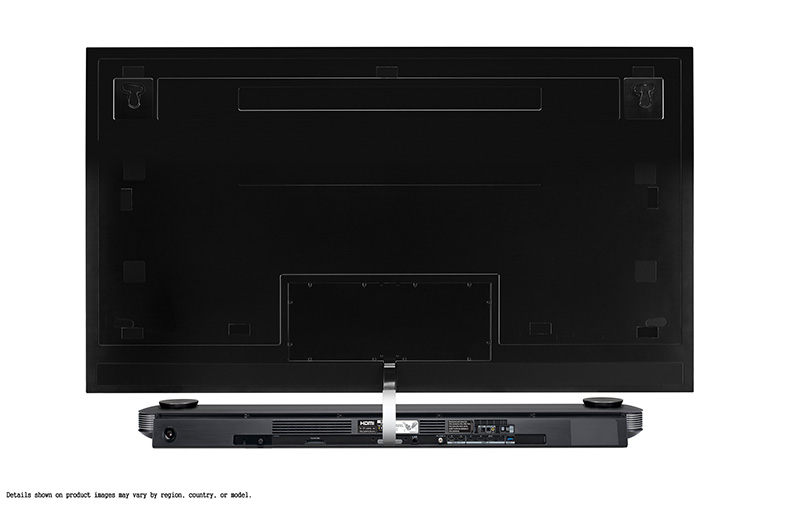 Parte trasera de un televisor negro grande con una barra de sonido debajo. Detalles de los puertos y conexiones visibles.