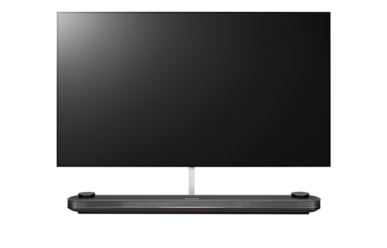 Televisor negro grande con soporte plateado y barra de sonido en la parte inferior.