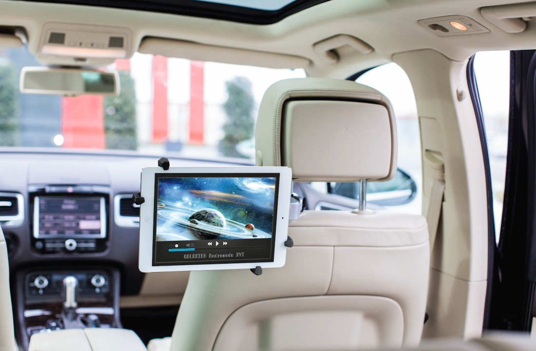 Tablette montée dans la voiture, affichant une vidéo spatiale. Vue intérieure de la voiture, supports noirs.