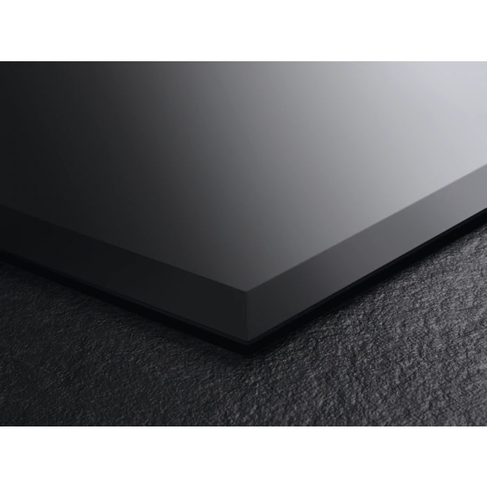 Close-up of a black ceramic cooktop surface. It is angled slightly.