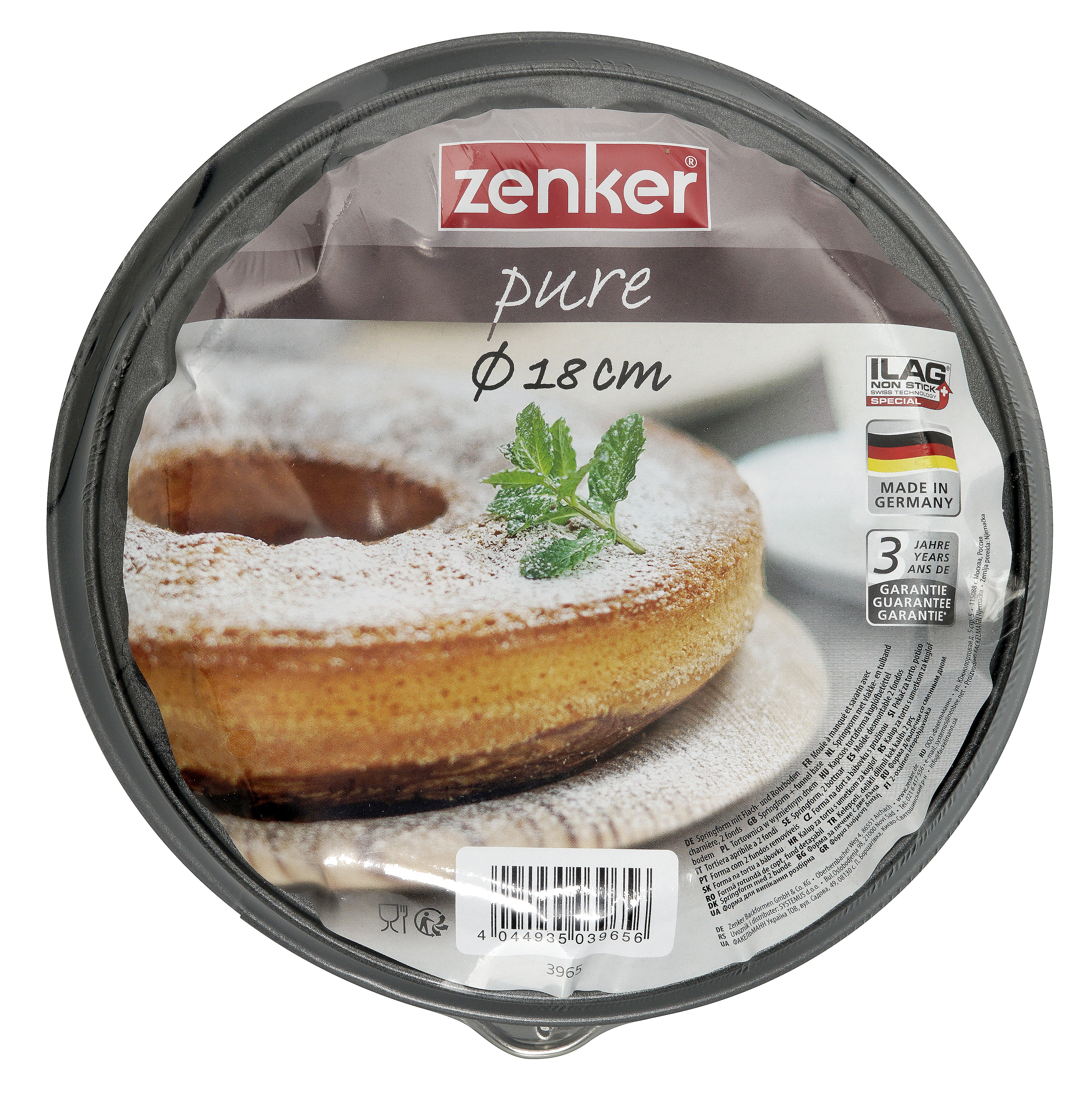 Runder Kuchen in einer Backform. Grüne Minzblätter. Schwarzer Rand und Verpackung mit Text und Etiketten.