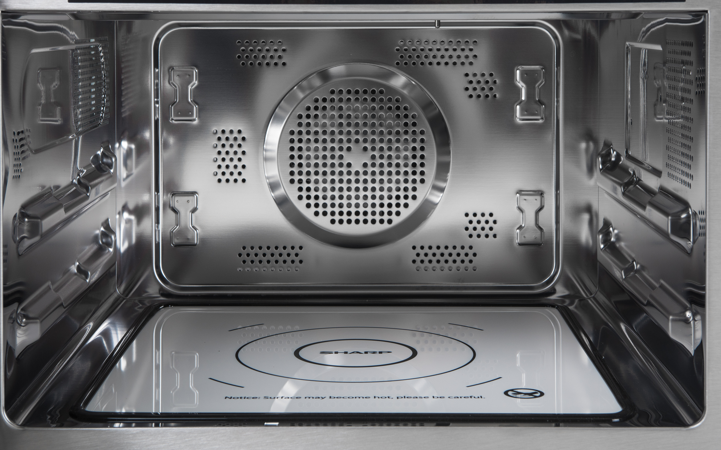 Inside of a stainless steel microwave with a SHARP plate.