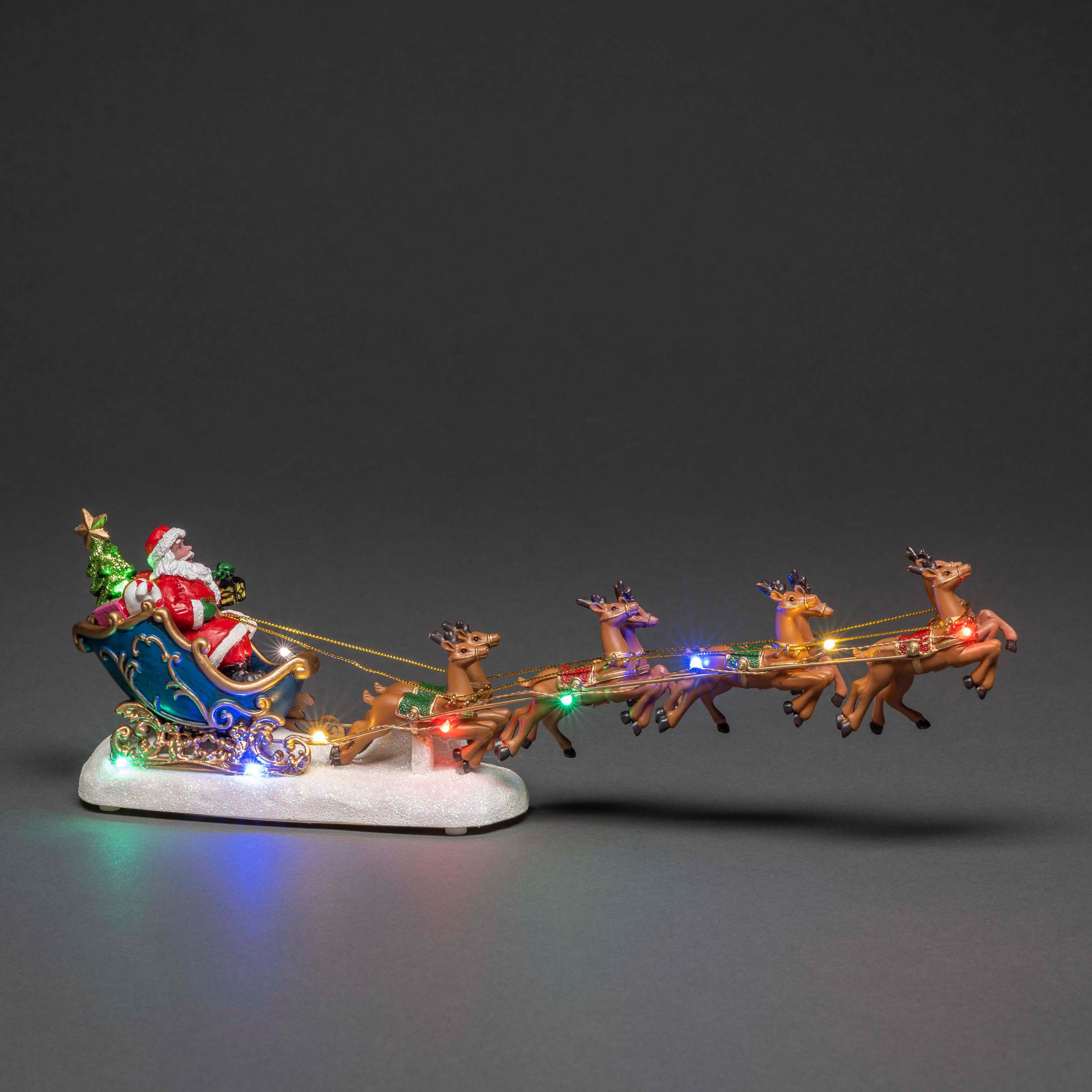 Weihnachtsdekoration: Weihnachtsmann in einem Schlitten, gezogen von Rentieren mit Lichtern.