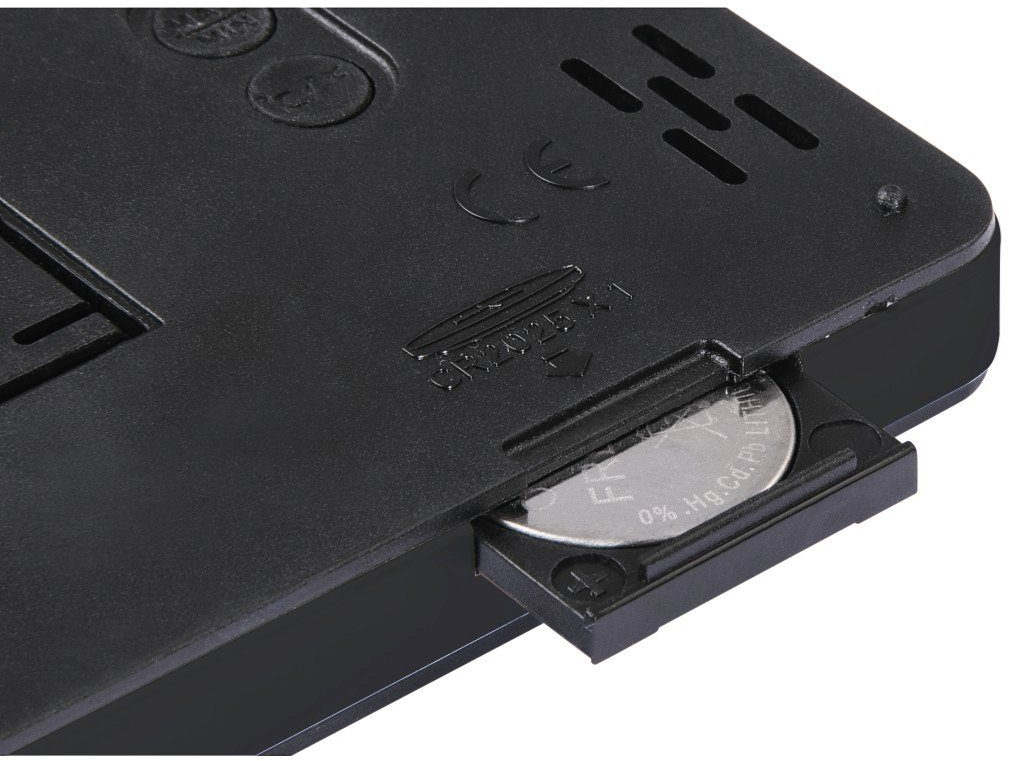 Primo piano della parte inferiore di un dispositivo nero con vano batteria aperto.