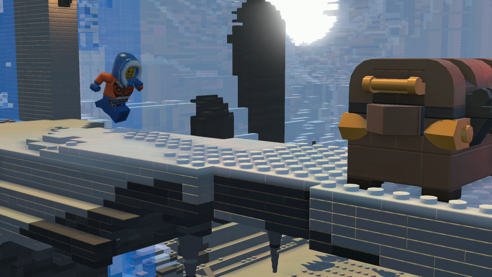 Eine Lego-Szene mit einer Lego-Figur, die über eine Lücke springt, einer Truhe und Legosteinen.