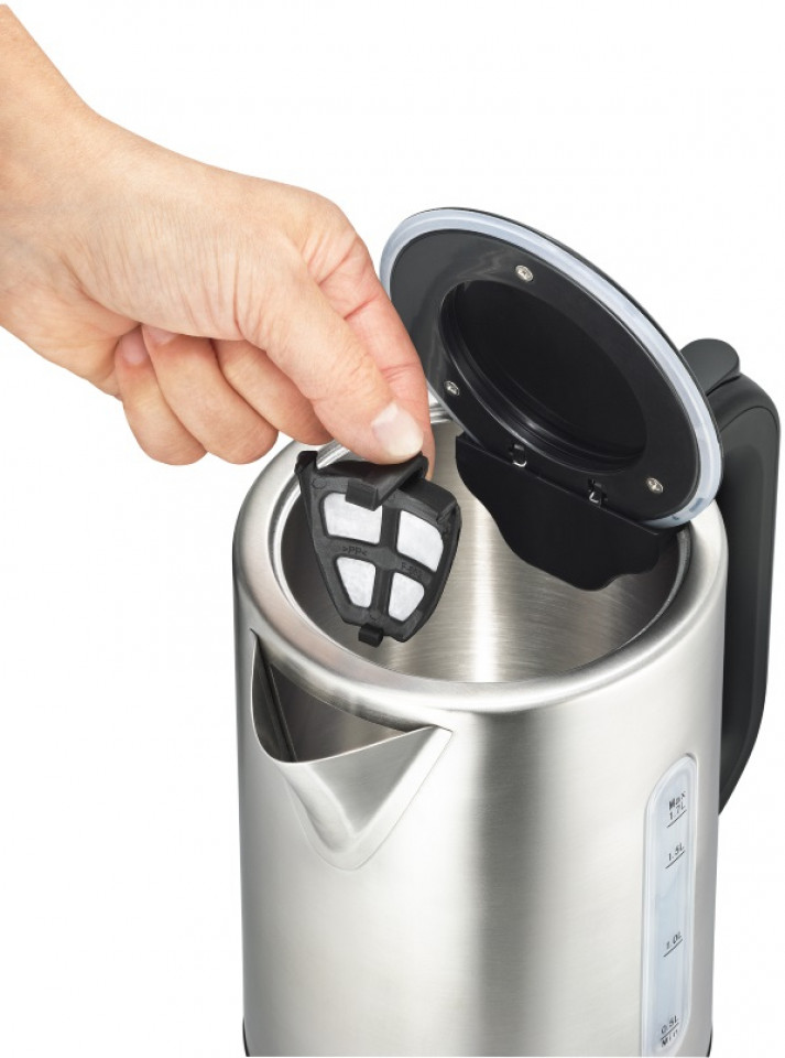 Hand, die einen Filter in einen silbernen Wasserkocher einsetzt. Schwarzer Filter, offener Deckel.