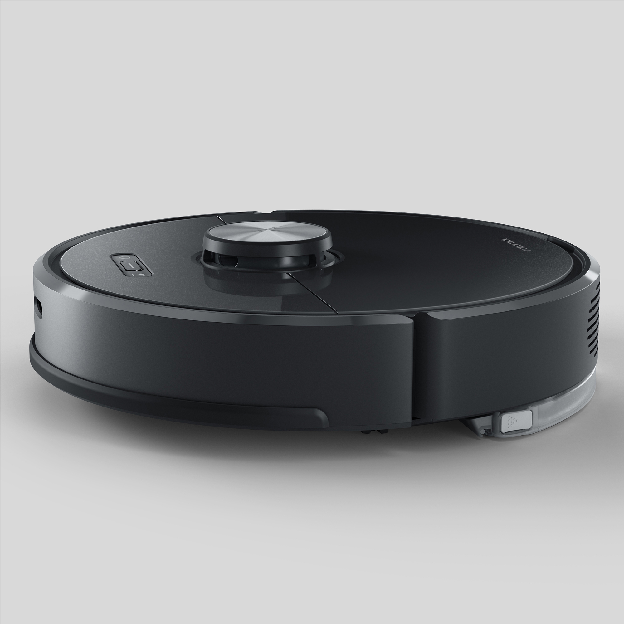 Nahaufnahme eines schwarzen Roboter-Staubsaugers vor helgrauem Hintergrund. Er hat eine runde Form mit silbernem Oberteil.