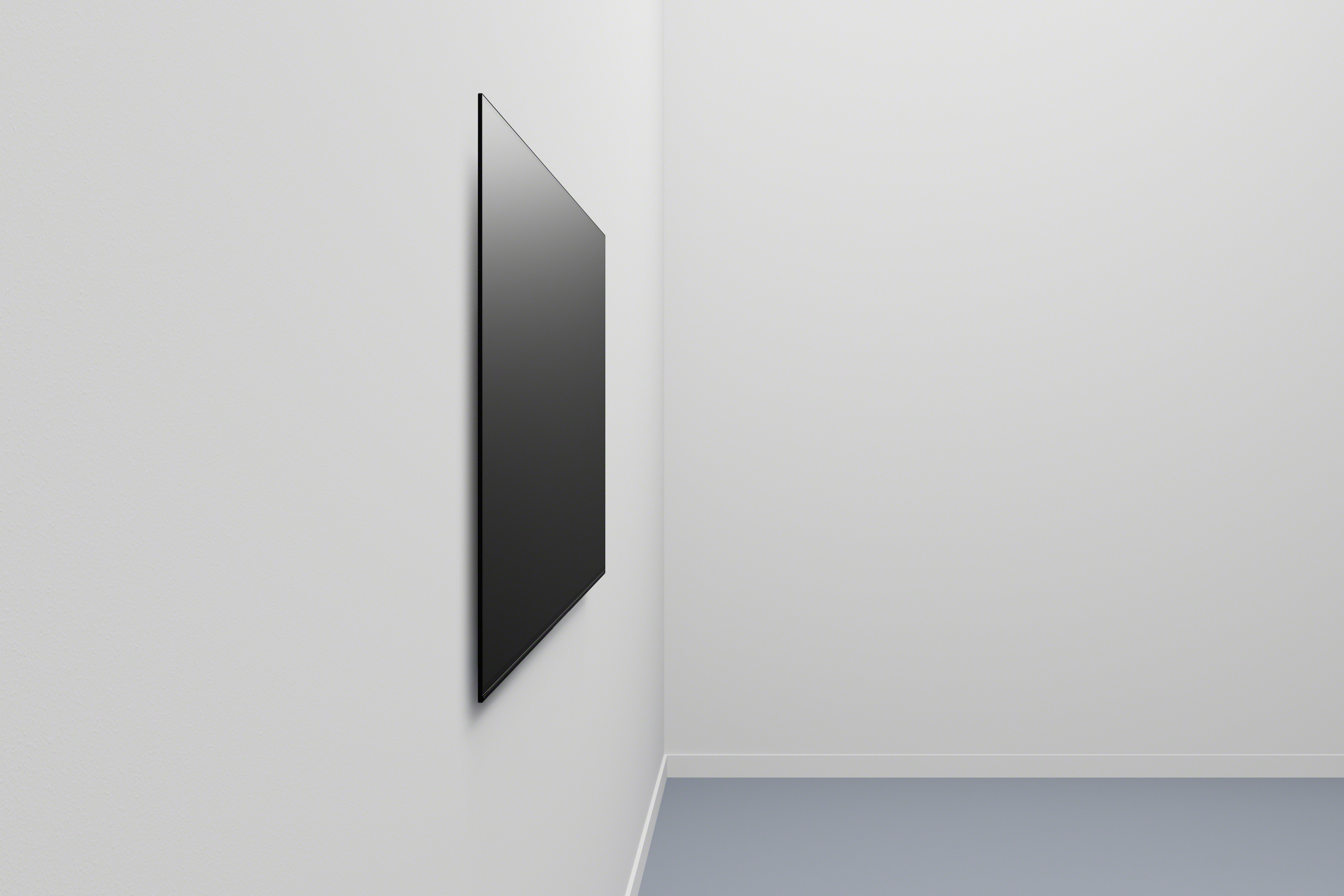 Ein schwarzer Fernseher ist an einer weißen Wand montiert. Der Fernseher ist angewinkelt und zeigt das Seitenprofil.