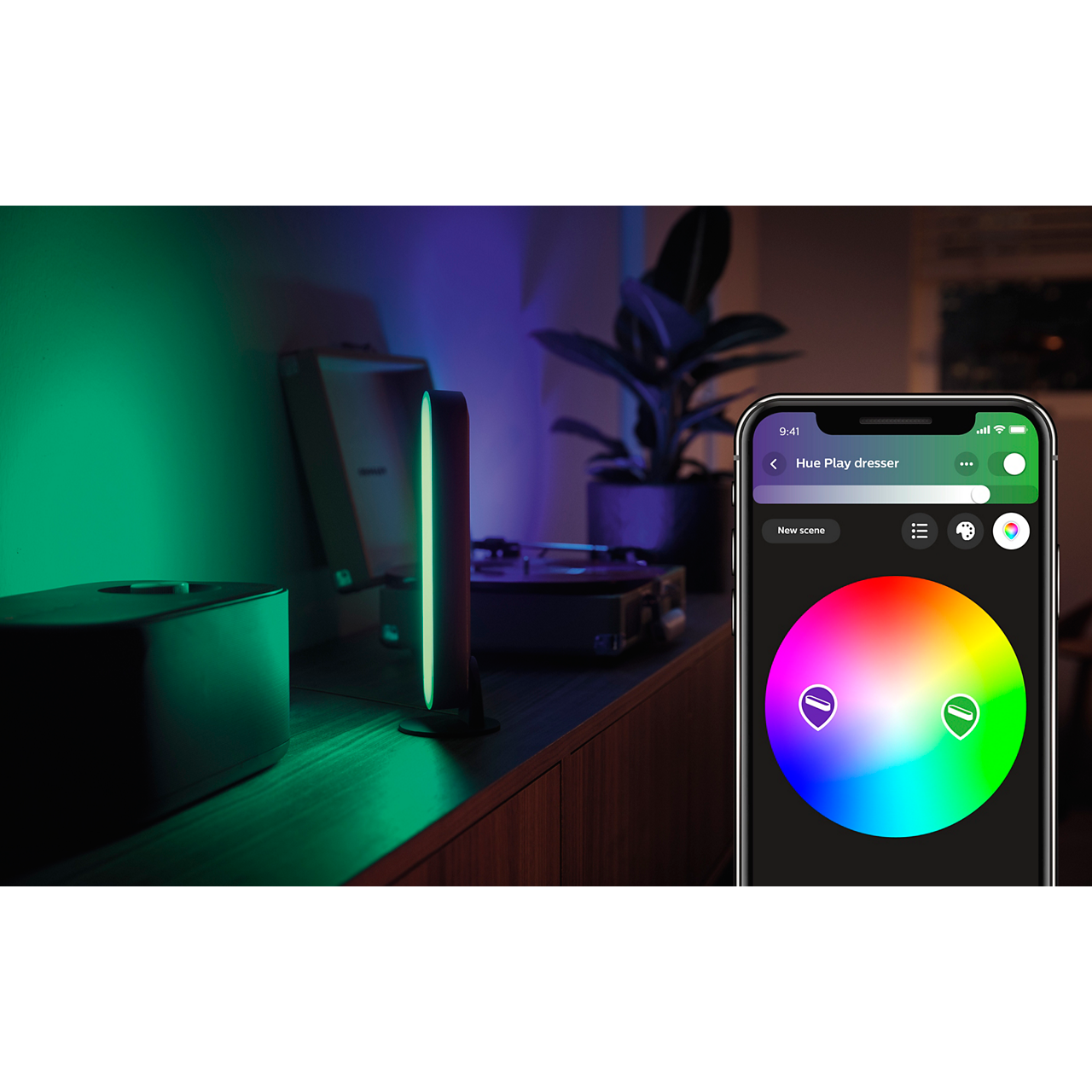 Interior scene with two light bars, a phone showing a color wheel, and a plant.