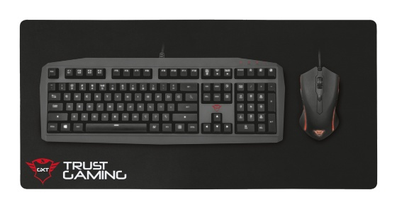 Siyah bir mousepad üzerinde siyah klavye ve fare. Trust Gaming markası görünür.