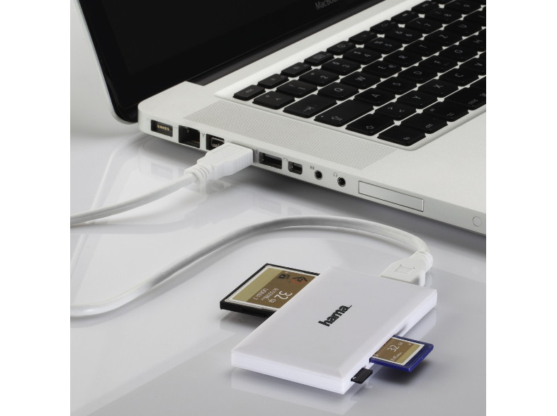 Fehér kártyaolvasó SD kártyákkal és egy USB kábellel, mely egy laptophoz csatlakozik.