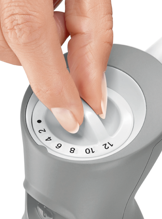 Eine Hand dreht einen Drehknopf an einem grauen Gerät mit Zahlen von 2 bis 12. Der Drehknopf ist weiß.