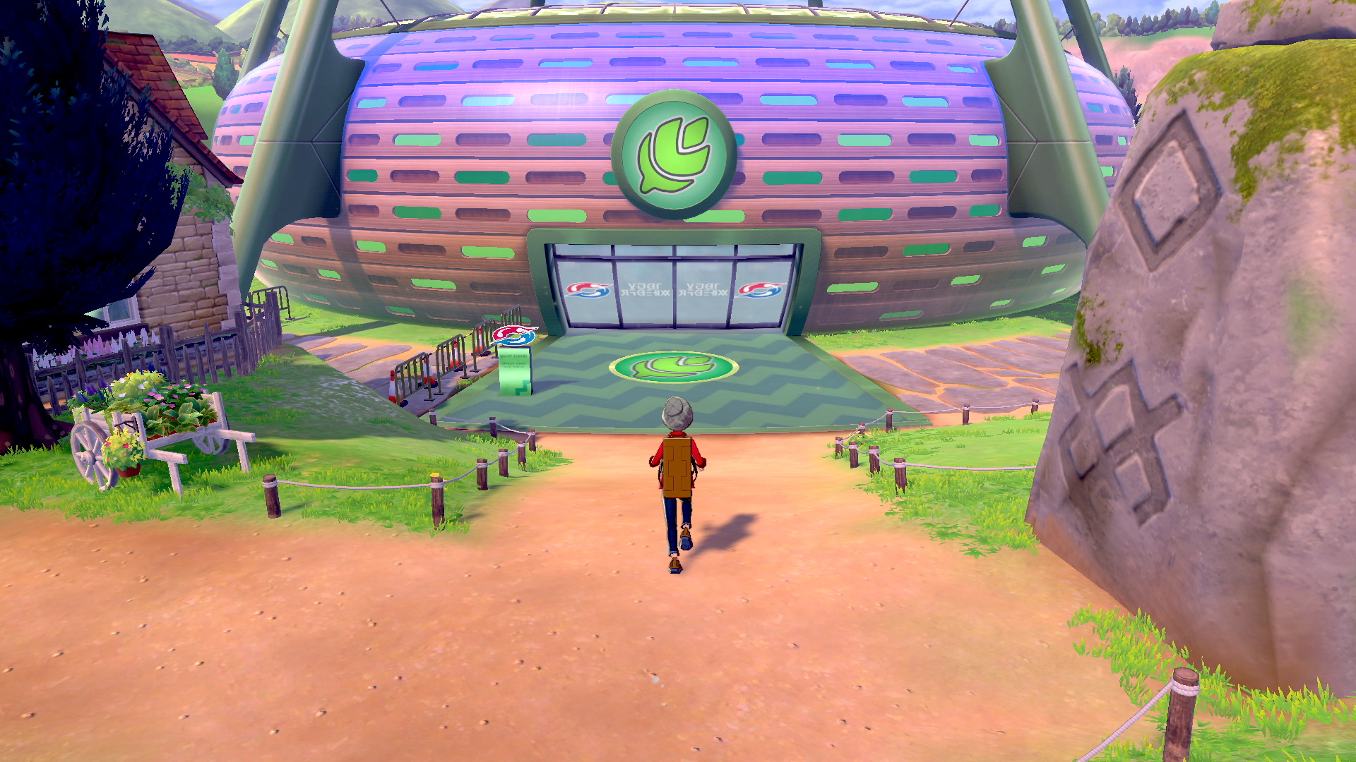 Una persona cammina verso uno stadio. Lo stadio ha un grande logo sulla parte anteriore.