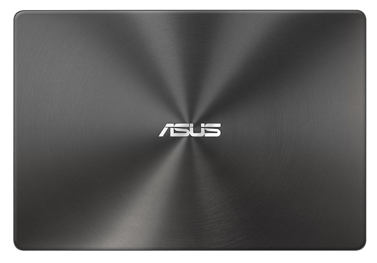 Dizüstü bilgisayarın arka kapağı. Konsantrik dairesel desen ve ASUS logosu ile koyu gri renktedir.