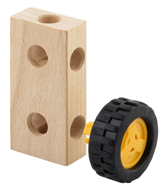 Holzspielklotz mit Löchern und einem gelb-schwarzen Rad daneben.