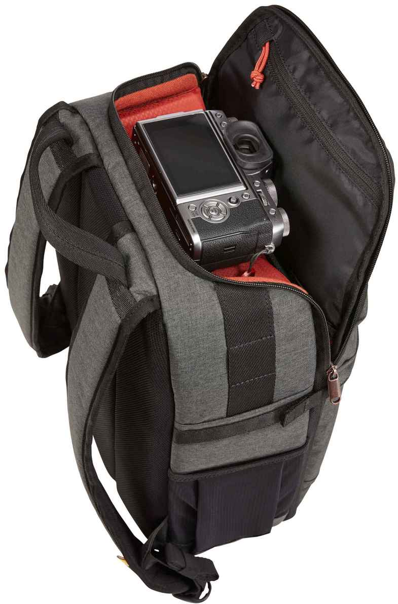 Grauer Kamerarucksack geöffnet, enthüllt eine Kamera im Inneren mit rotem Futter. Reißverschlüsse, Gurte und Taschen sind sichtbar.