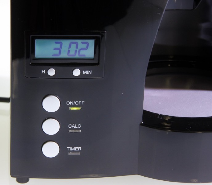 Cafetera negra con pantalla digital que muestra la hora y botones.
