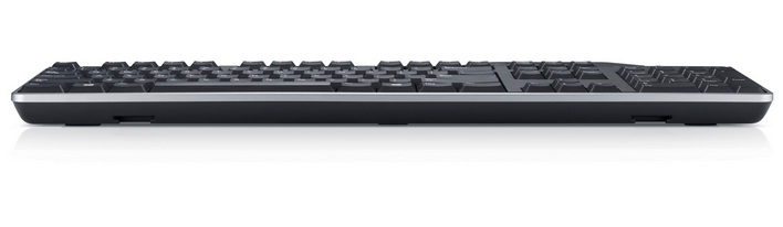 Eine schwarze Computertastatur mit silberner Umrandung liegt auf einer weißen Oberfläche. Tasten sind sichtbar. Seitenansicht.