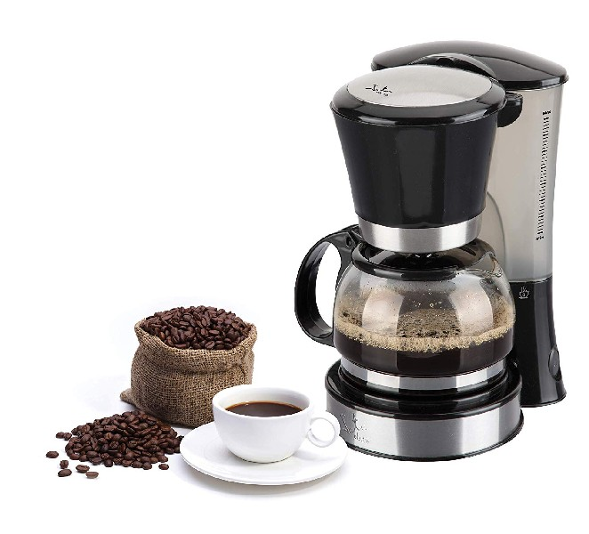 Cafetera con café, granos de café y una taza de café sobre fondo blanco.