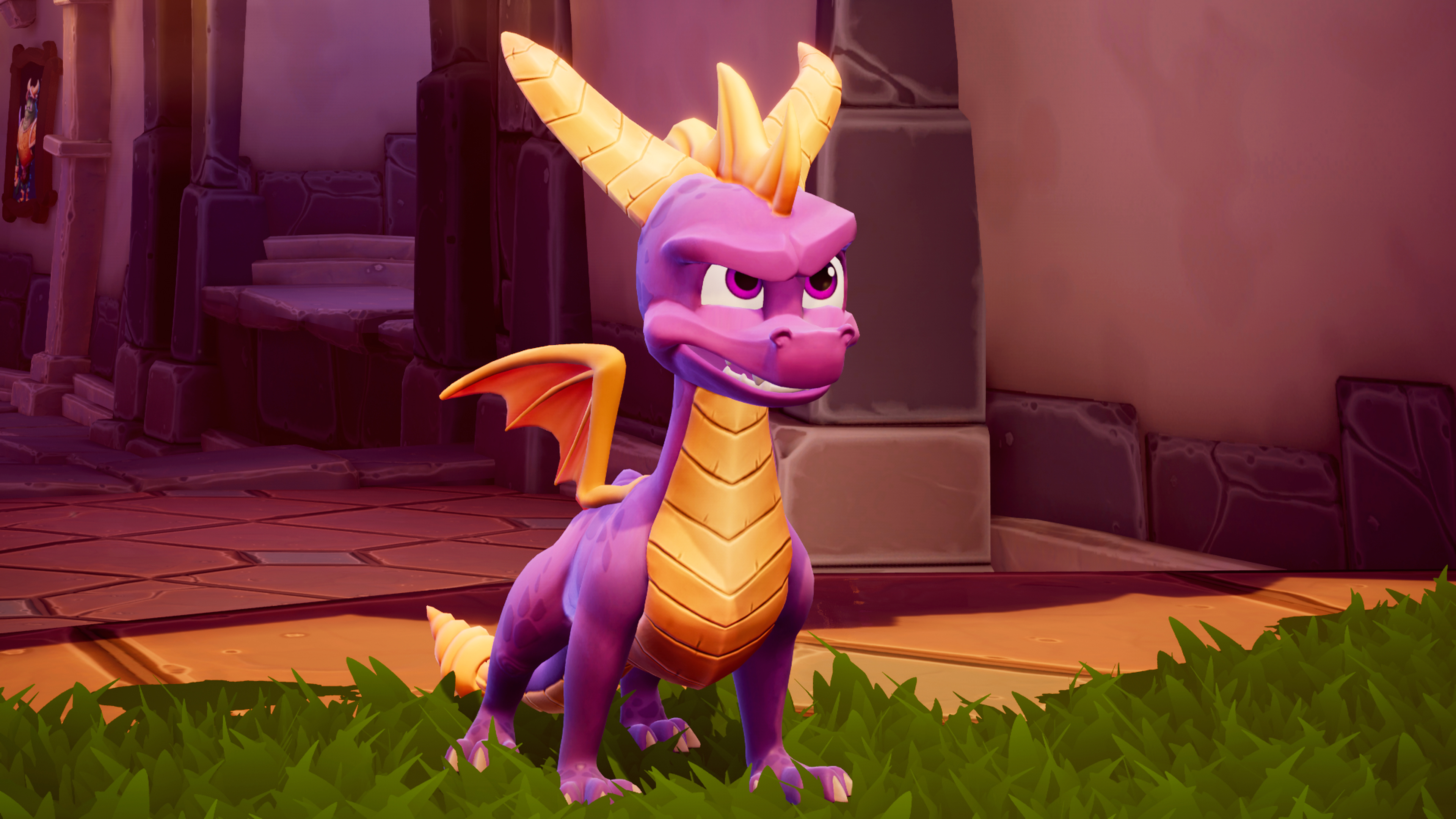Spyro der Drache steht in einem lila-goldenen Outfit und blickt den Betrachter an. Grünes Gras.