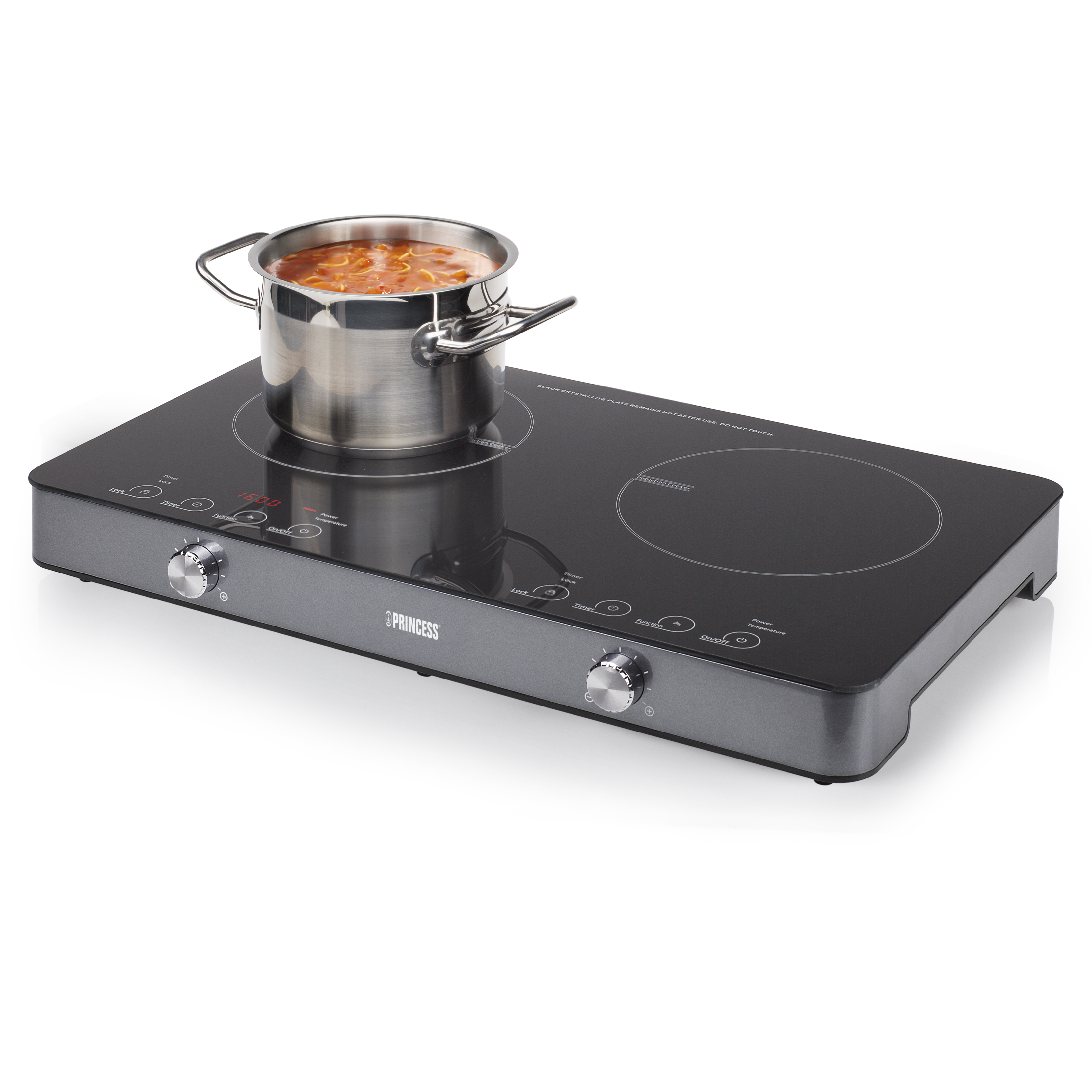 Zwarte inductiekookplaat met zilveren pan met eten erop. De kookplaat heeft knoppen.