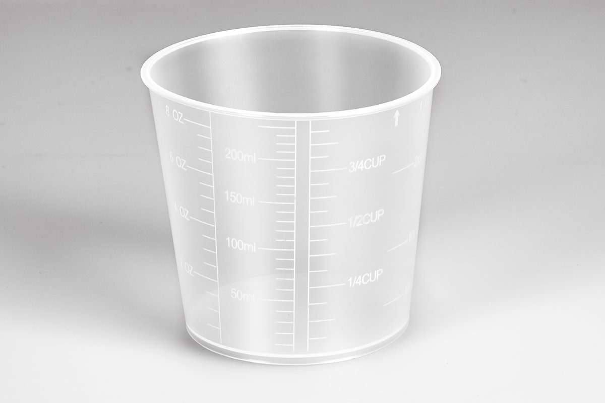 Transparante plastic maatbeker met meetmarkeringen in ml en kopjes. Witte achtergrond.
