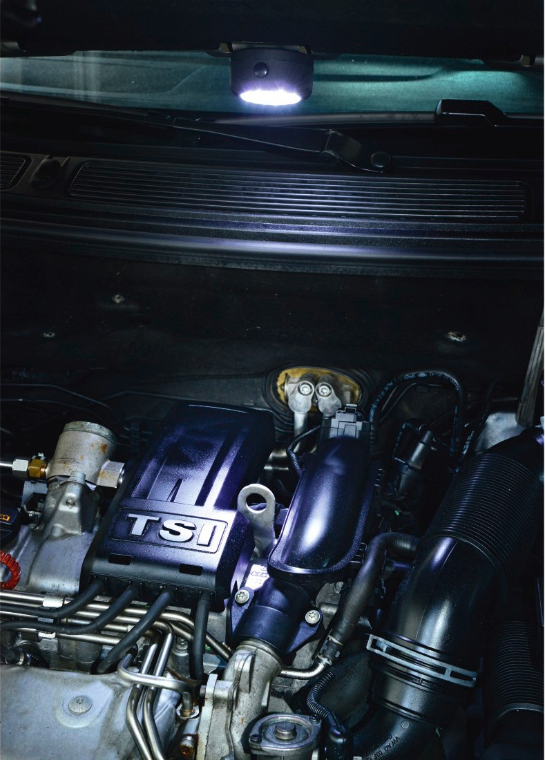 Compartiment moteur éclairé. Couvercle TSi et tuyaux visibles.