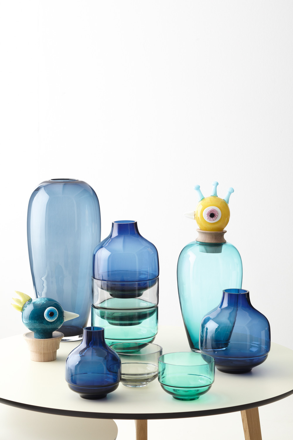 Sortiment bunter Glasvasen auf einem weißen Tisch. Verschiedene Formen und Farben.