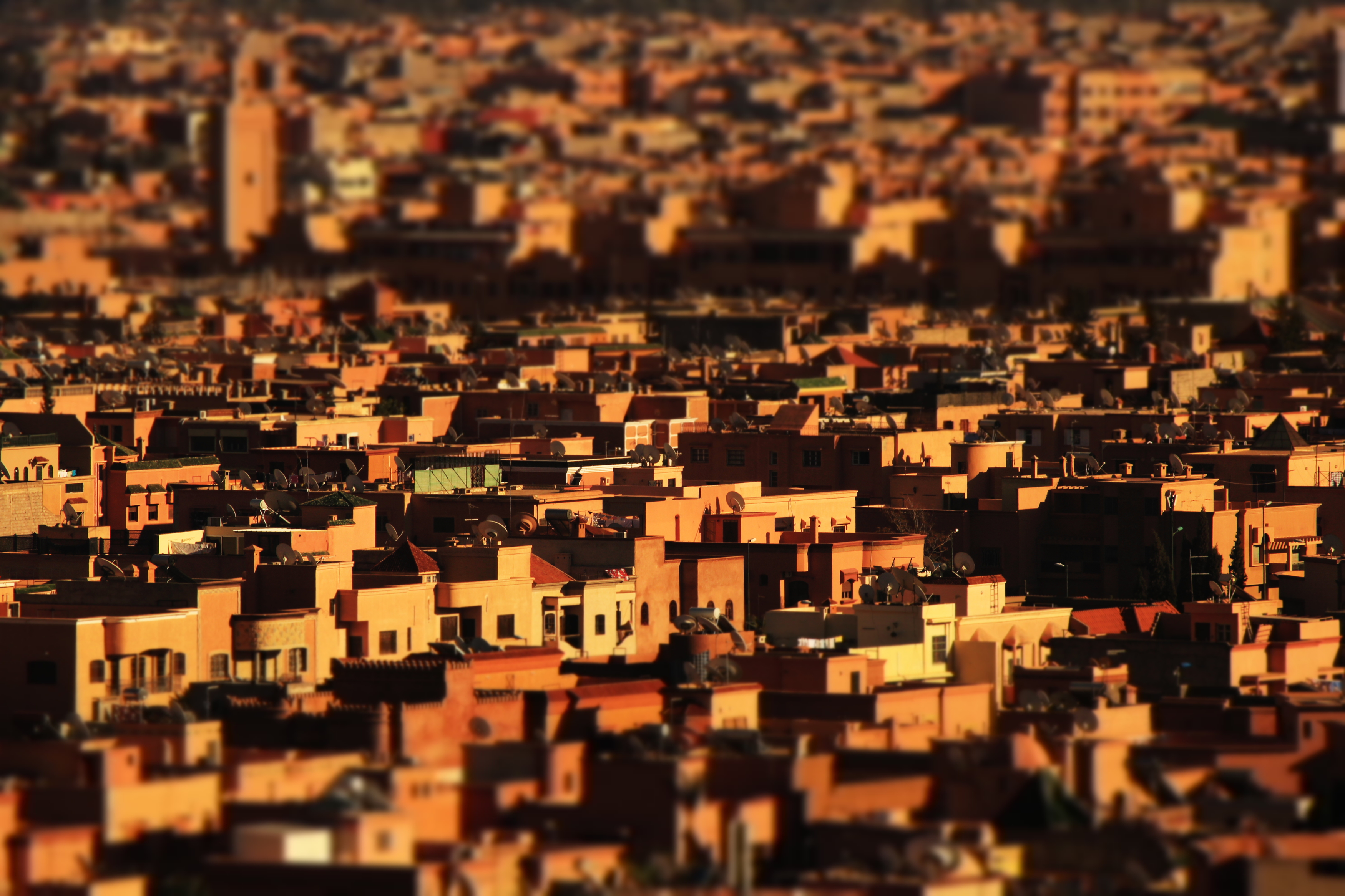 Eine Luftaufnahme einer Stadt mit orangefarbenen Gebäuden, Dächern und unscharfem Hintergrund.