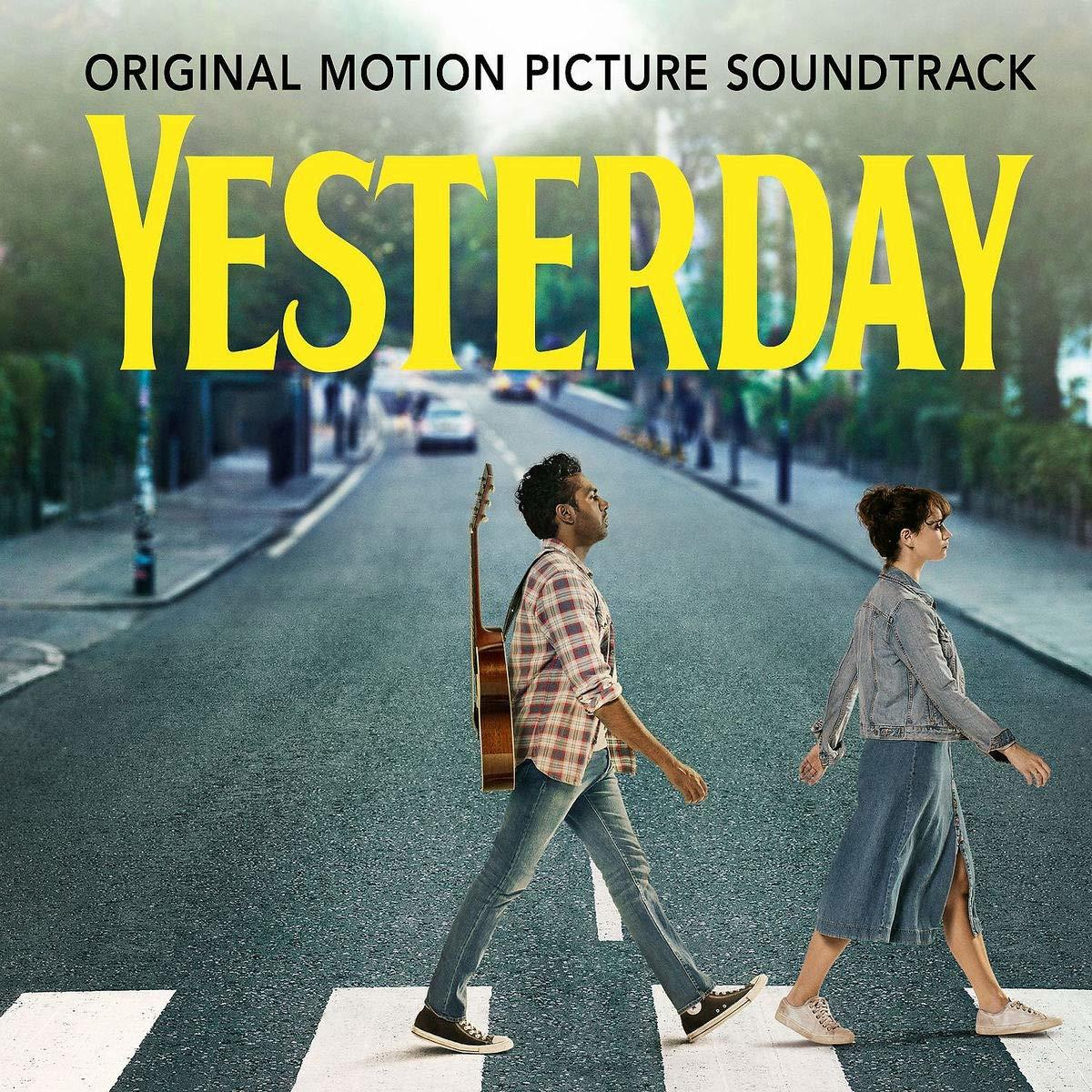 Twee mensen lopen over een zebrapad. Eén draagt een gitaar. De titel "Yesterday" staat erboven. Auto's op de wazige achtergrond.