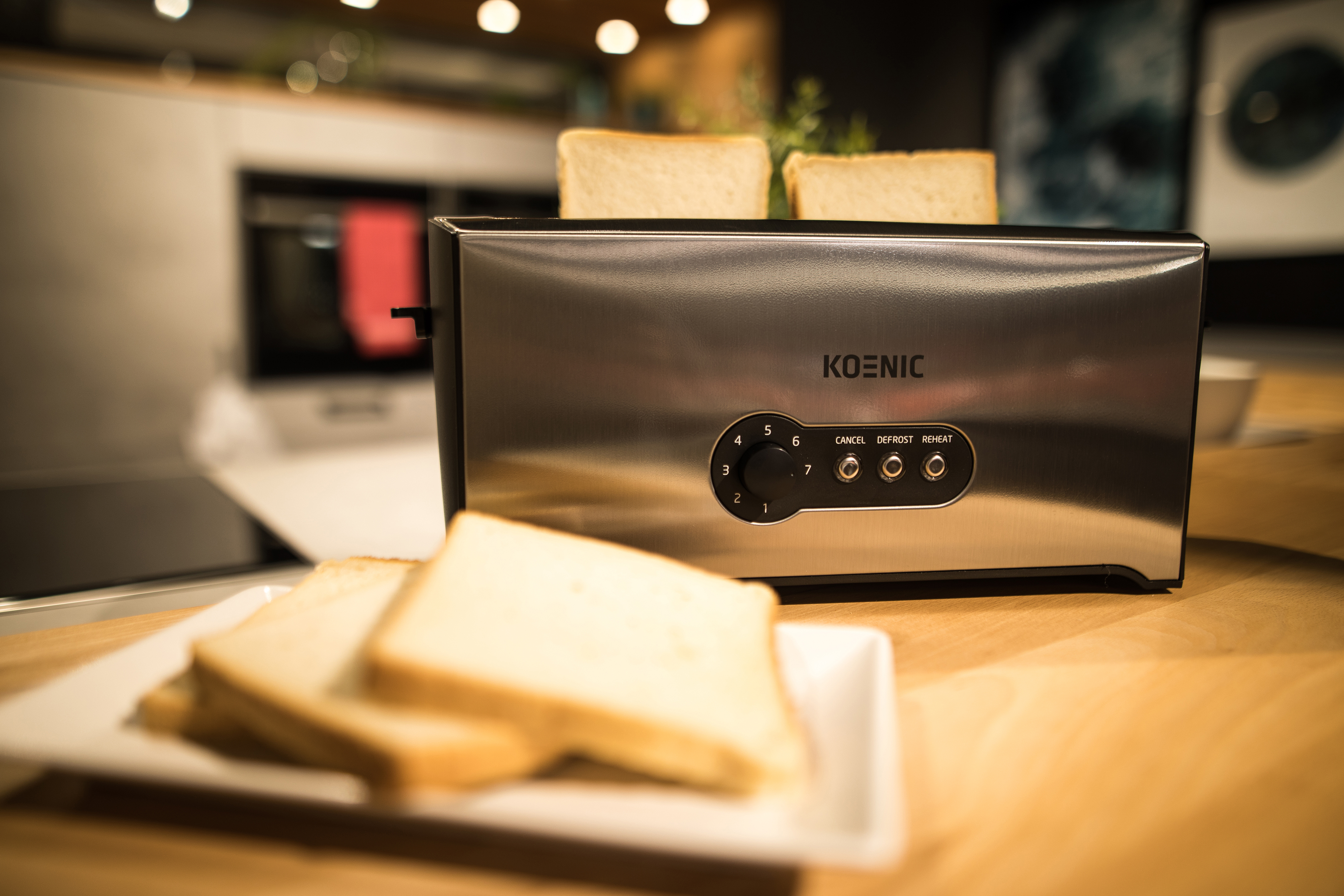 Toaster mit Brotscheiben auf Holztisch. Küchenhintergrund.