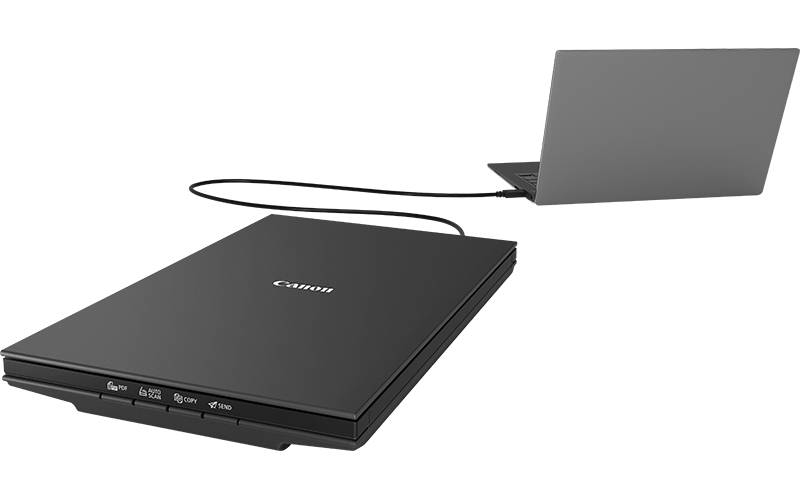 Bir dizüstü bilgisayara bağlı düz yataklı tarayıcı. Tarayıcı siyah, dizüstü bilgisayar gri.