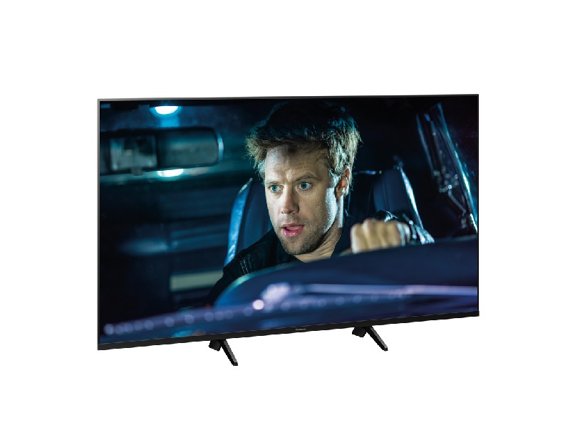 Un hombre parece sorprendido, sentado en un coche, mirando una pantalla de televisión.