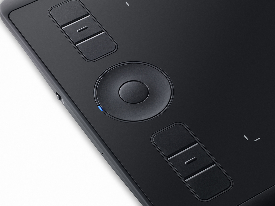 Close-up of a black drawing tablet. It has buttons and a circular control panel.