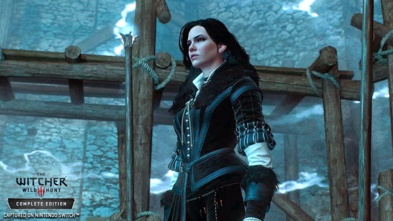 Eine Frau in dunkler Kleidung blickt nach oben, in einer Spielszene. Der Titel The Witcher Wild Hunt ist sichtbar.