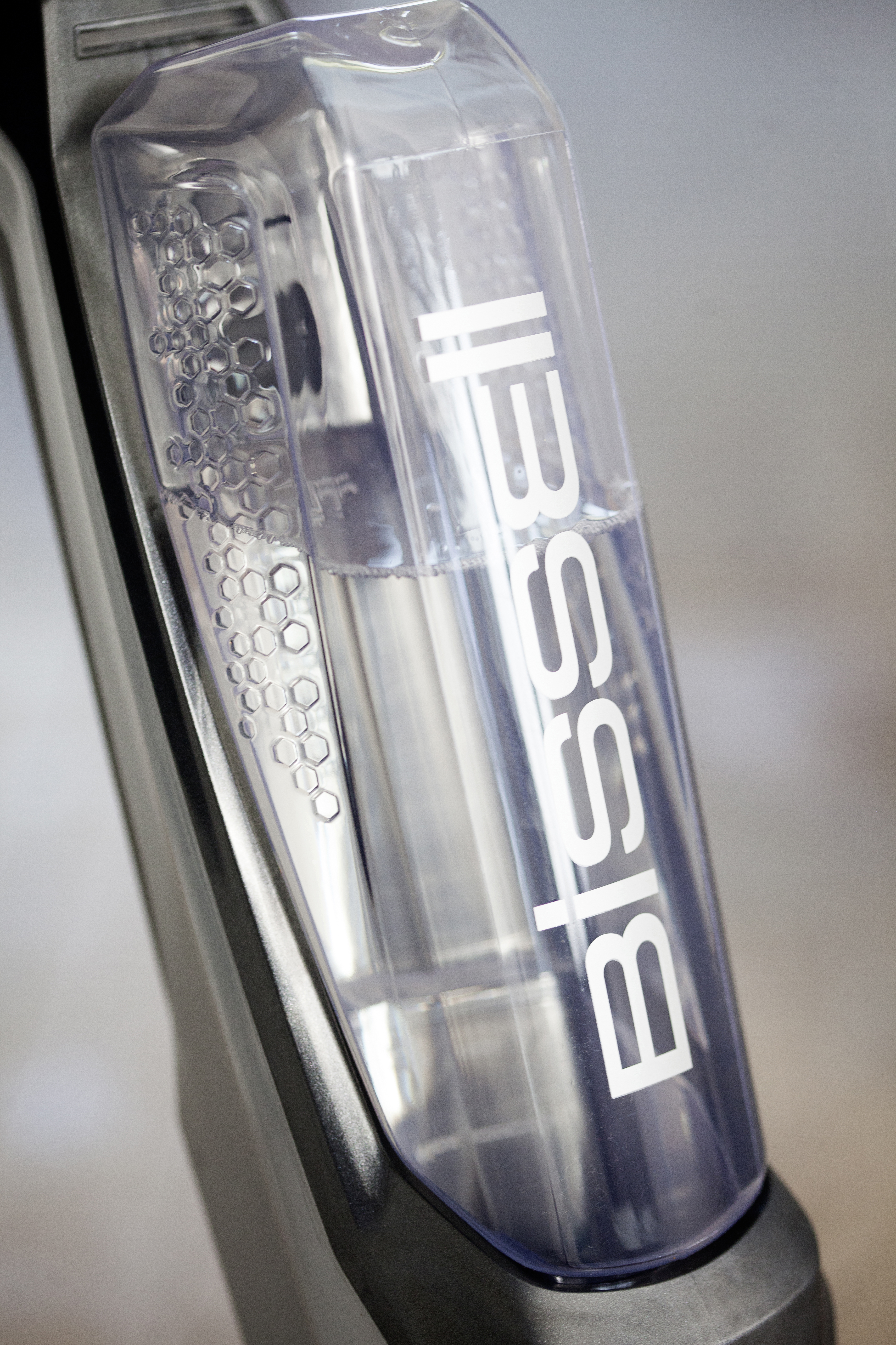 Ein durchsichtiger Bissell-Vakuumwassertank mit Wasser und dem Bissell-Logo.