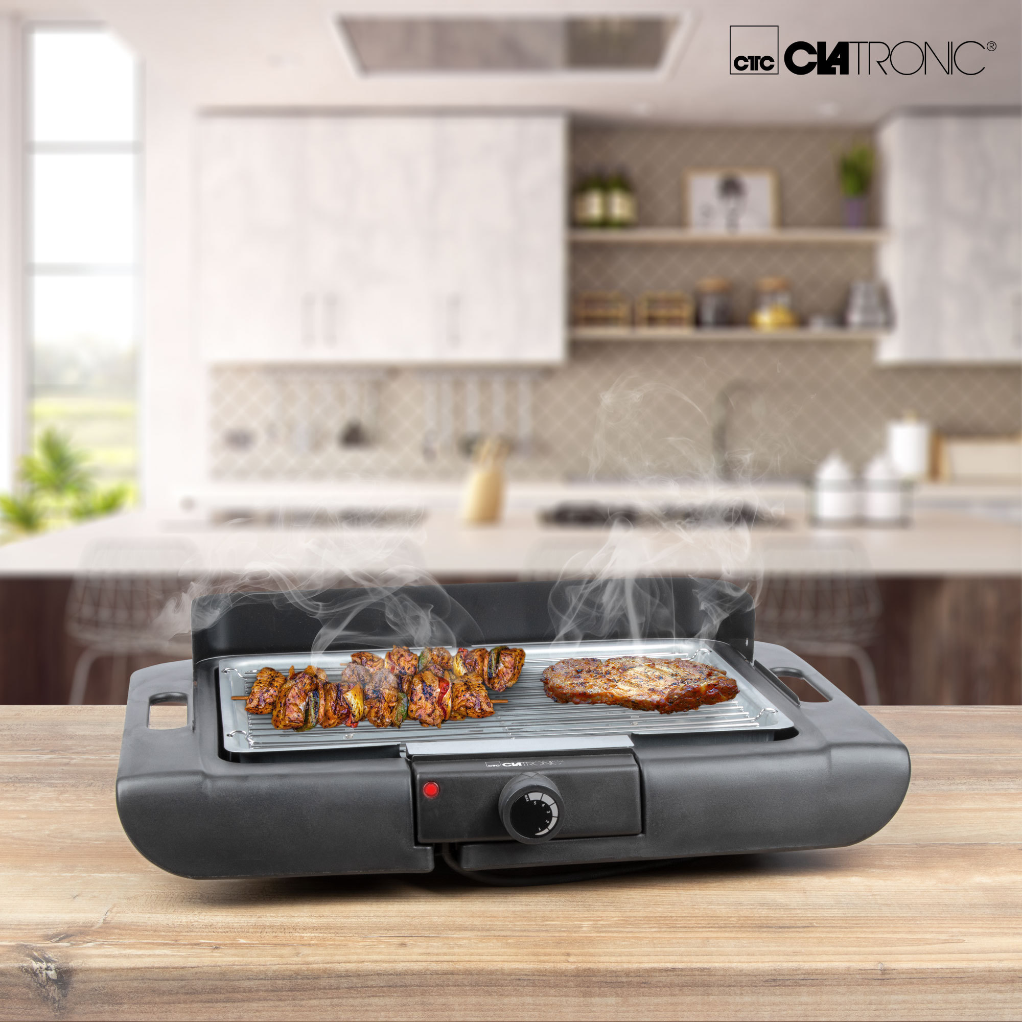 Elektrischer Grill mit Fleisch. Der Grill steht auf einem Holztisch, Küche im Hintergrund.