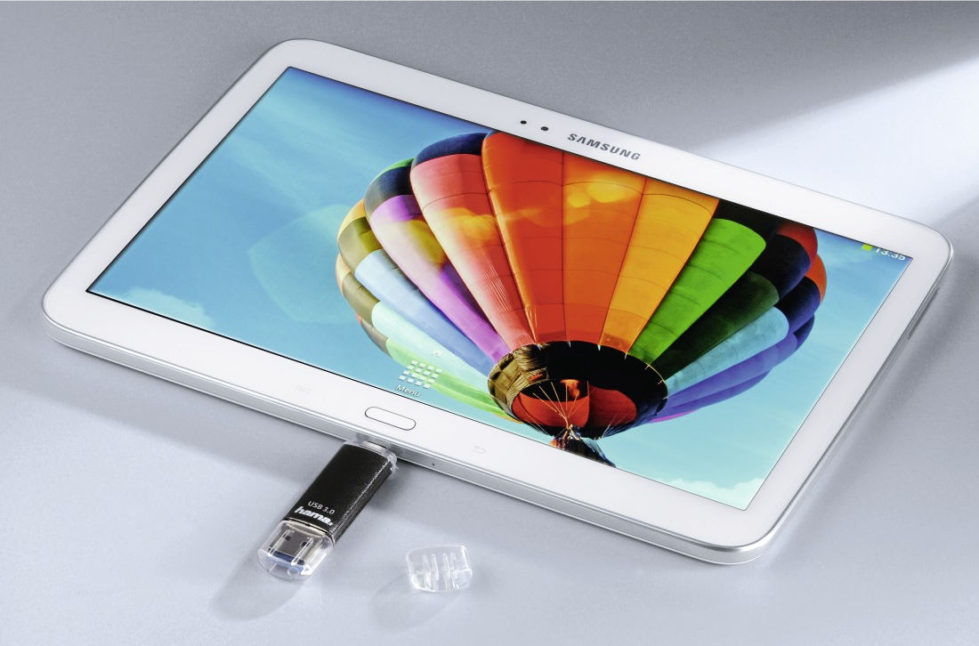 Tablette blanche avec une image de montgolfière colorée. Une clé USB est branchée.
