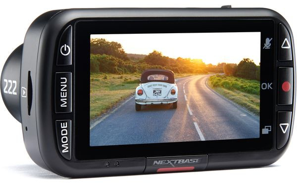 Zwarte dashcam met een scherm dat een auto op een weg met zonsondergang weergeeft.