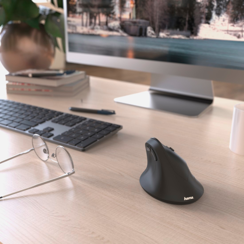 A desk setup with a computer monitor, keyboard, mouse, and glasses.