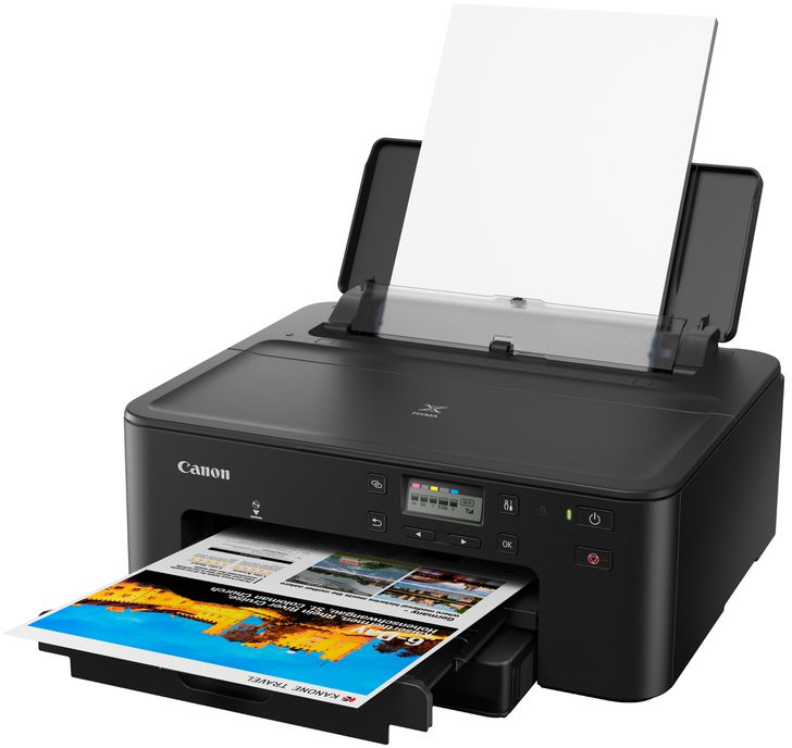 A black Canon printer printing a color page.