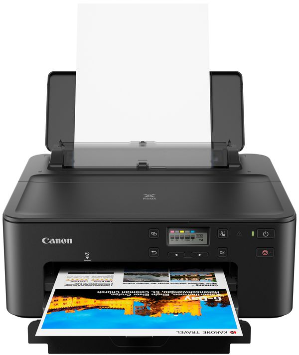 Black Canon printer printing a document. The document has a colorful image with text. White paper in the tray.