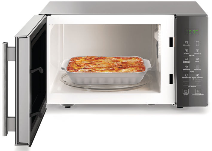 Mikrowelle mit offener Tür, Gericht Lasagne im Inneren.