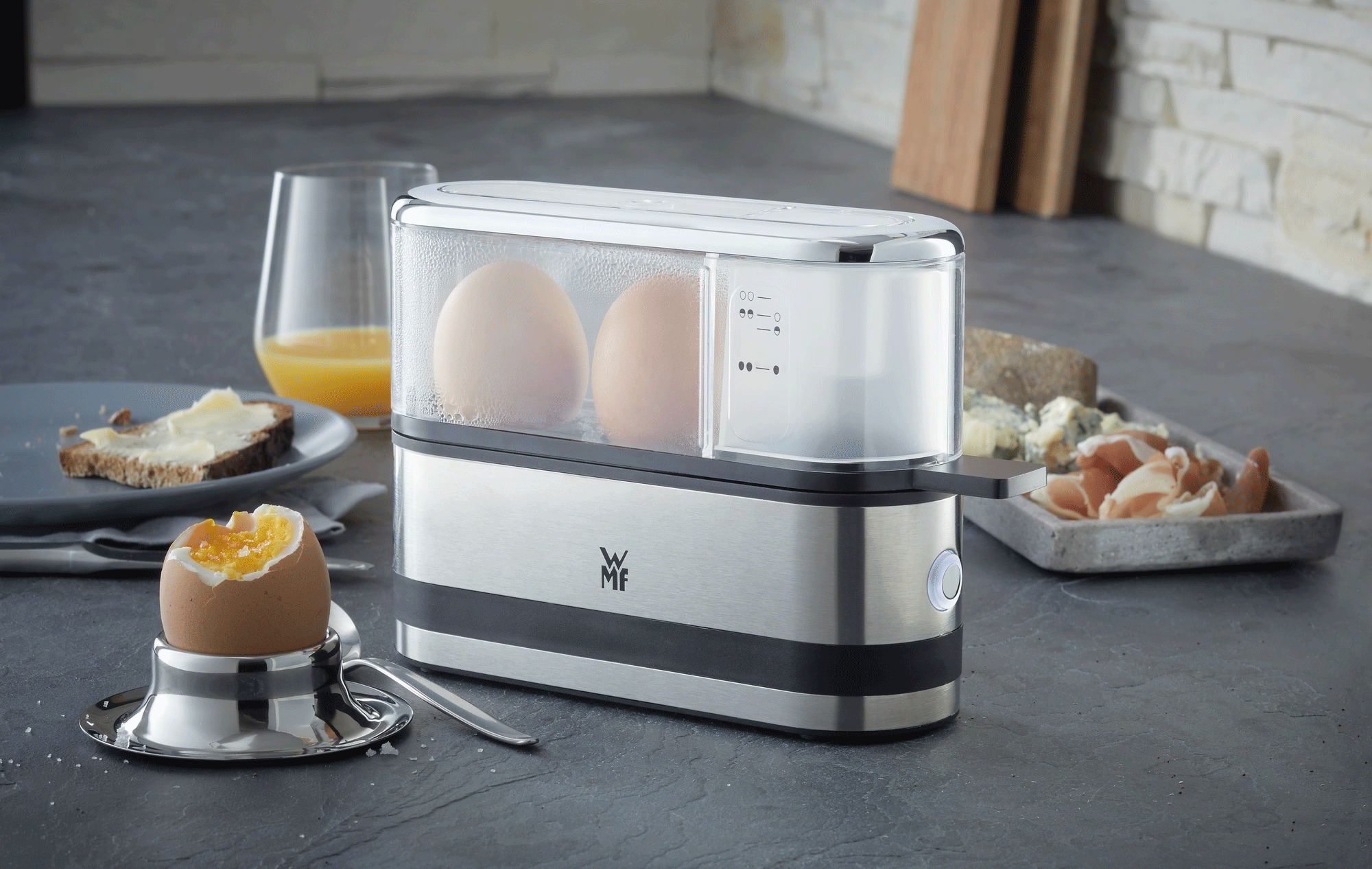 Egg boiler with eggs and breakfast food.