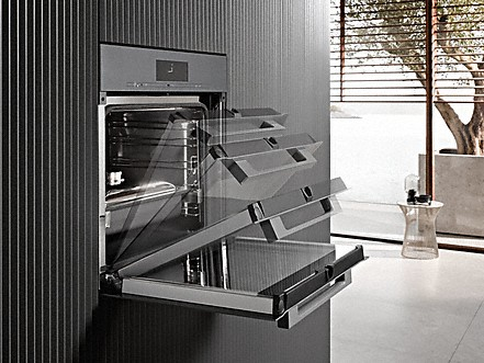 Ein Backofen mit geöffneter Tür und Tablett, moderne Küche.