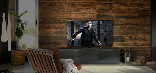 Escena de sala de estar. TV grande, pared de madera, sillón de cuero. Diseño moderno.