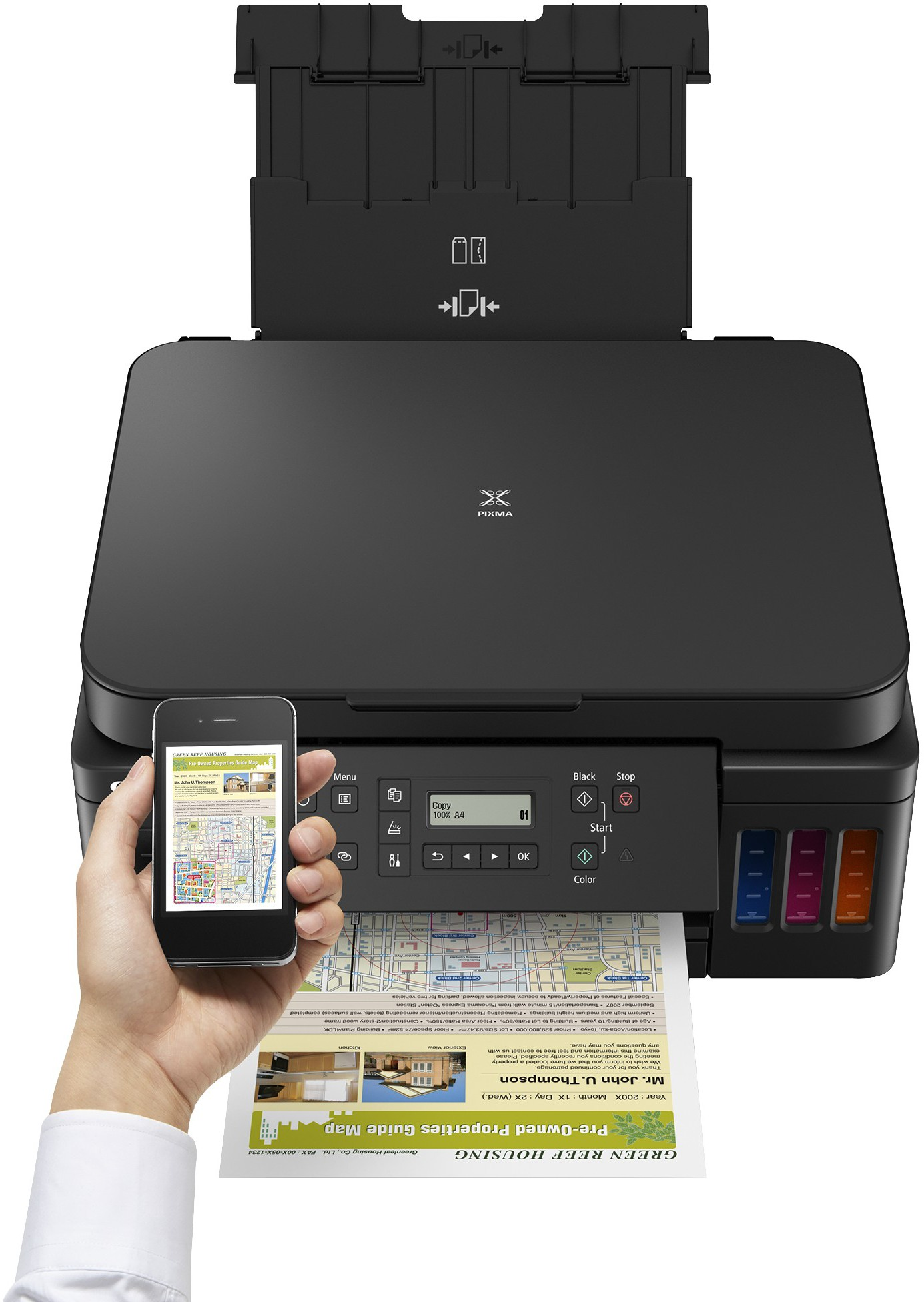 Schwarzer Canon-Drucker, der ein Papier mit einer Karte druckt, das von einer Hand und einem Smartphone gehalten wird.