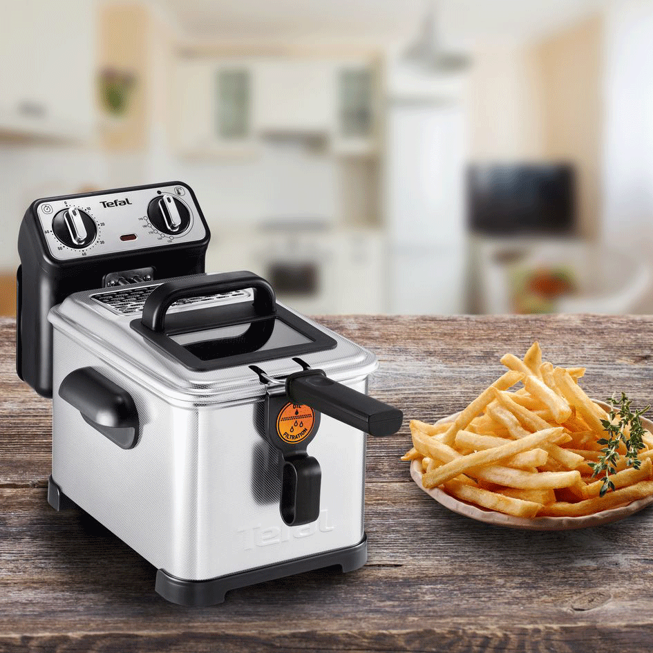 Een zilveren friteuse met friet.